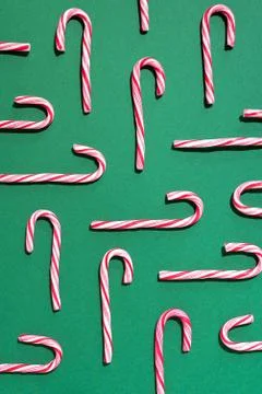 Pattern of Christmas candy cane on green background. Top view. Flat lay Stock Photos