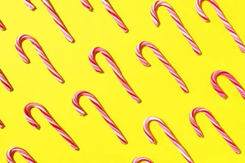 Pattern of Christmas candy cane on yellow background. Top view. Flat lay Stock Photos