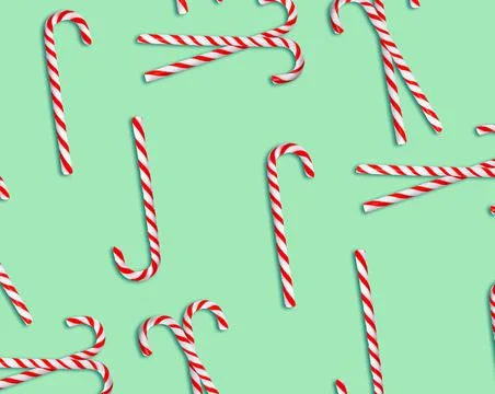 Pattern of Christmas candy canes on pale green background, top view Stock Photos