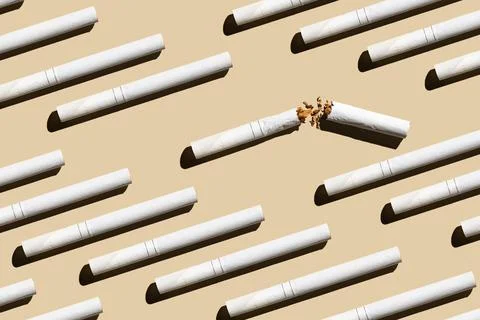 Pattern from cigarettes on a pastel beige background.Give up smoking cigarett Stock Photos