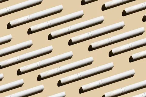 Pattern from cigarettes on a pastel beige background.Give up smoking cigarett Stock Photos