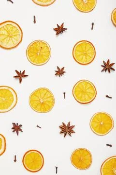 Pattern of cloves, anise and dried oranges on white background Stock Photos