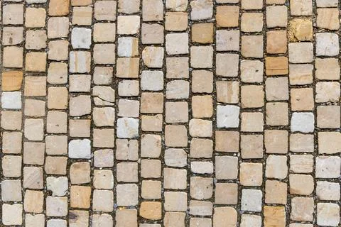 Pattern of cobblestone at a historic street in light yellow stone color Stock Photos