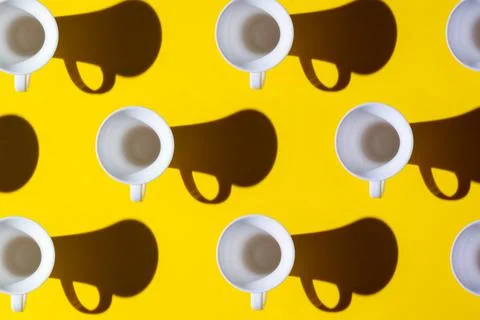 Pattern of coffee cups from a top view casting a hard shadow with the silhoue Stock Photos