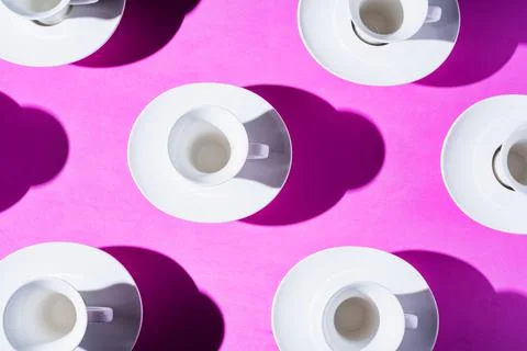 Pattern of coffee cups from a top view casting a hard shadow with the silhoue Stock Photos