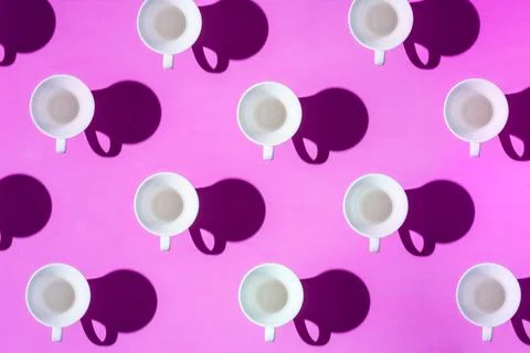 Pattern of coffee cups from a top view casting a hard shadow with the silhoue Stock Photos