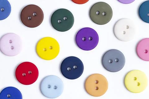 A pattern of colored buttons close-up on a white background, sewing supplies. 스톡 사진