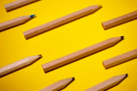 Pattern of colored pencils on a yellow background Stock Photos