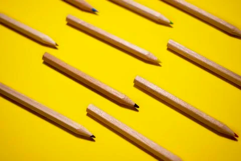 The pattern of colored wood pencils on a bright yellow background Stock Photos