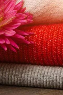 Pattern of colorful knitted sweaters closeup. Handmade merino wool product... Stock Photos