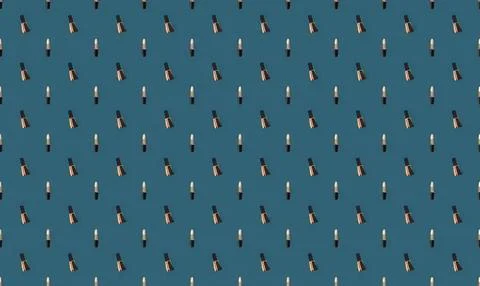 Pattern of colorful lipstick tubes on blue background Stock Illustration