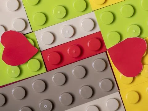 Pattern of colorful plastic bricks with two red hearts above 스톡 사진