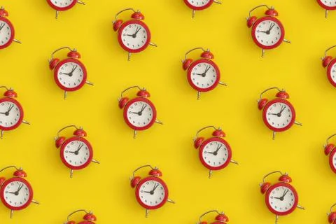 Pattern composition of black antique alarm clock on yellow background. Flat.. Stock Photos