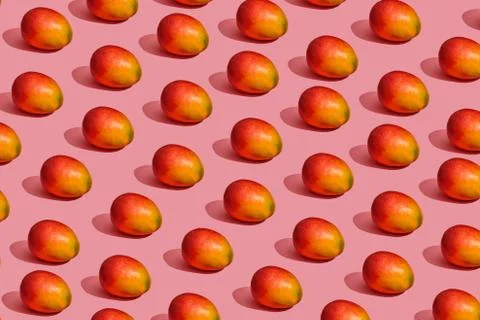 Pattern composition of a sweet tasty mango lying next to a pink background , top Stock Photos