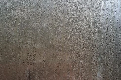 Pattern of condensation forms on a chilled glass surface, with water drople.. Stockfoto's