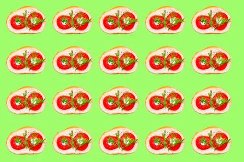 The pattern consists of a sandwich with tomatoes and greens on a light green  Foto stock