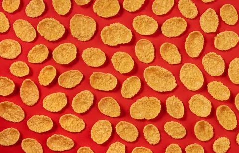 Pattern of corn flakes on red color background, top view Pattern of corn f... Stock Photos