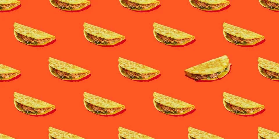 Pattern of corn tortilla tacos stuffed with vegetables and meat on a red b... Stock Photos