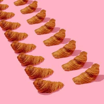 A pattern of croissants on a pink background 스톡 사진