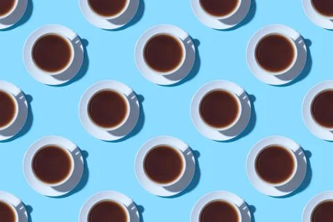 Pattern of cups of black coffee or tea on a blue background. Stock Photos