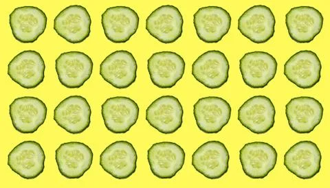 Pattern with cut green cucumbers on a yellow background. Stock Photos
