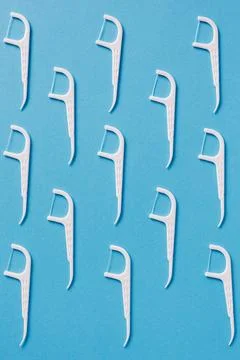 Pattern of dental floss with a plastic toothpick on blue background Stockfoto's