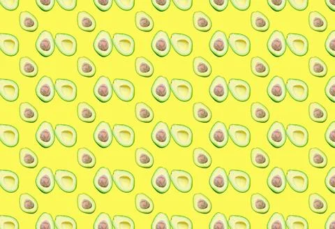 A pattern with different avocado halves on a yellow background. Stock Photos