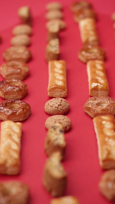 A pattern of different cookies laid out on a red background Stock Footage 171744909