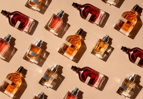 Pattern of different perfume bottles on a pastel beige background in the Stock Photos