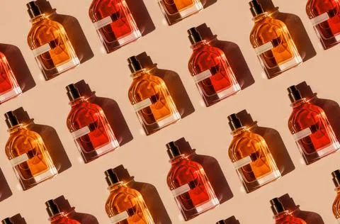 Pattern of different perfume bottles on a pastel beige background in the Stock Photos