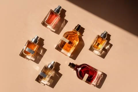 Pattern of different perfume bottles on a pastel beige background in the Stock Photos