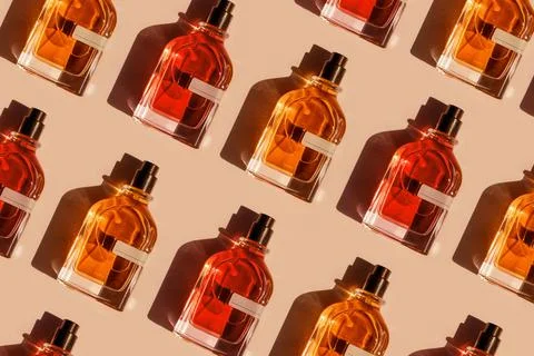 Pattern of different perfume bottles on a pastel beige background in the Stock Photos