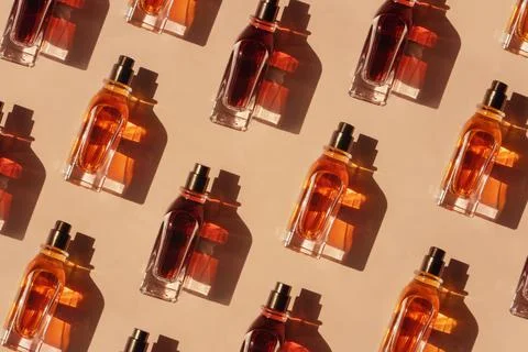 Pattern of different perfume bottles on a pastel beige background in the Stock Photos