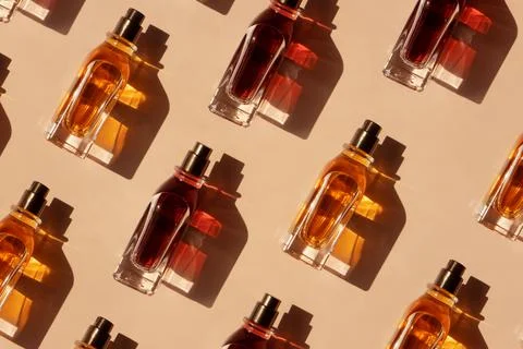 Pattern of different perfume bottles on a pastel beige background in the Stock Photos