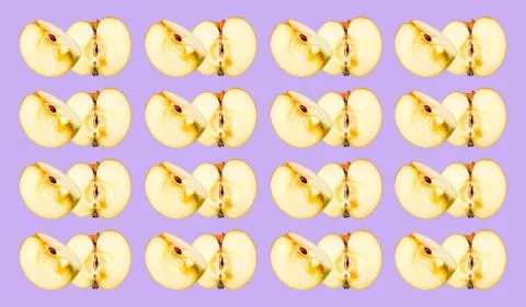 A pattern of different pieces of a cut Apple on a purple background. The frui Stock Photos