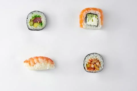 Pattern of different types of sushi rolls with tuna and salmon on a white bac Stock Photos