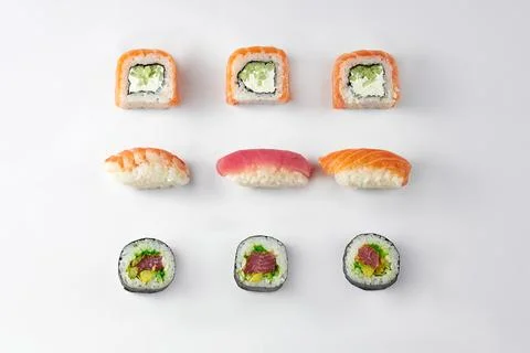 Pattern of different types of sushi rolls with tuna and salmon on a white bac Stock Photos