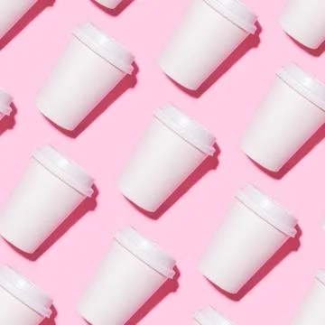 Pattern of disposable coffee cups on a pink background. Foto stock