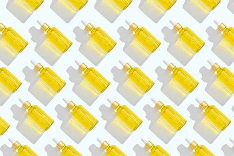 Pattern of dropper bottles with white pipette and yellow liquid on white back Stock Photos