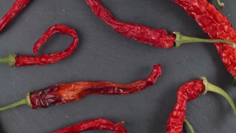 Pattern of dry hot peppers on a black background; top view; close-up Video stock 172361714