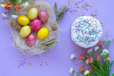 Pattern of Easter eggs in the nest and Easter cake on a purple background 스톡 사진