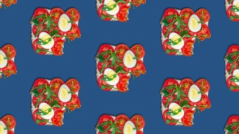 Pattern eating a toast with cream cheese, tomatoes, quail eggs and pea sprouts. Stock Footage 129400778