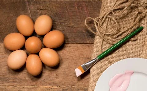 Pattern of eggs on wooden table for Easter with paintbrush Stock Photos