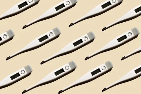 Pattern of electronic modern thermometers isolated on a pastel beige backgrou Stock Photos
