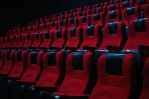 Pattern empty red velvet seats in the cinema auditorium. Empty cinema, before Stock Photos
