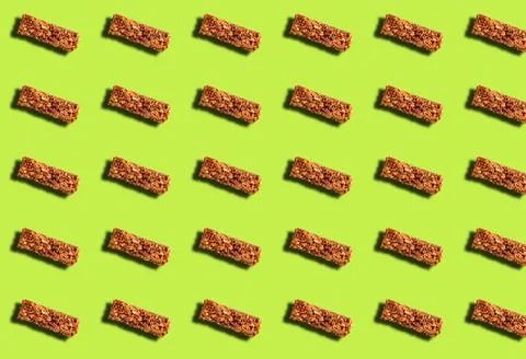 A pattern with an energy bar on a green background. Sports nutrition. Fotos Stock