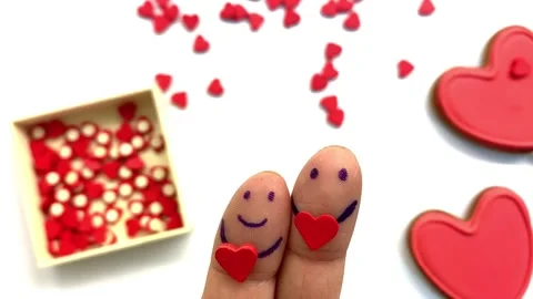 Pattern on fingers is in shape of little men holding a red heart in their hands Stock Footage 263708304