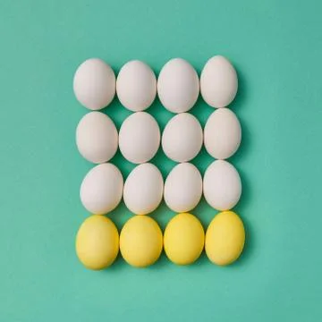 Pattern in the form of a square of painted yellow and white eggs on a green Foto stock