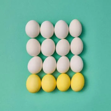 Pattern in the form of a square of painted yellow and white eggs on a gree... Foto stock