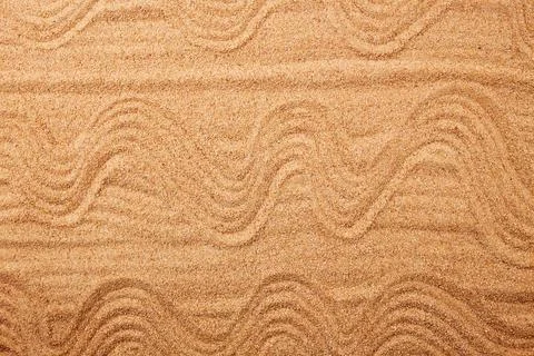 A pattern in the form of waves on the sand on the beach. Stock Photos